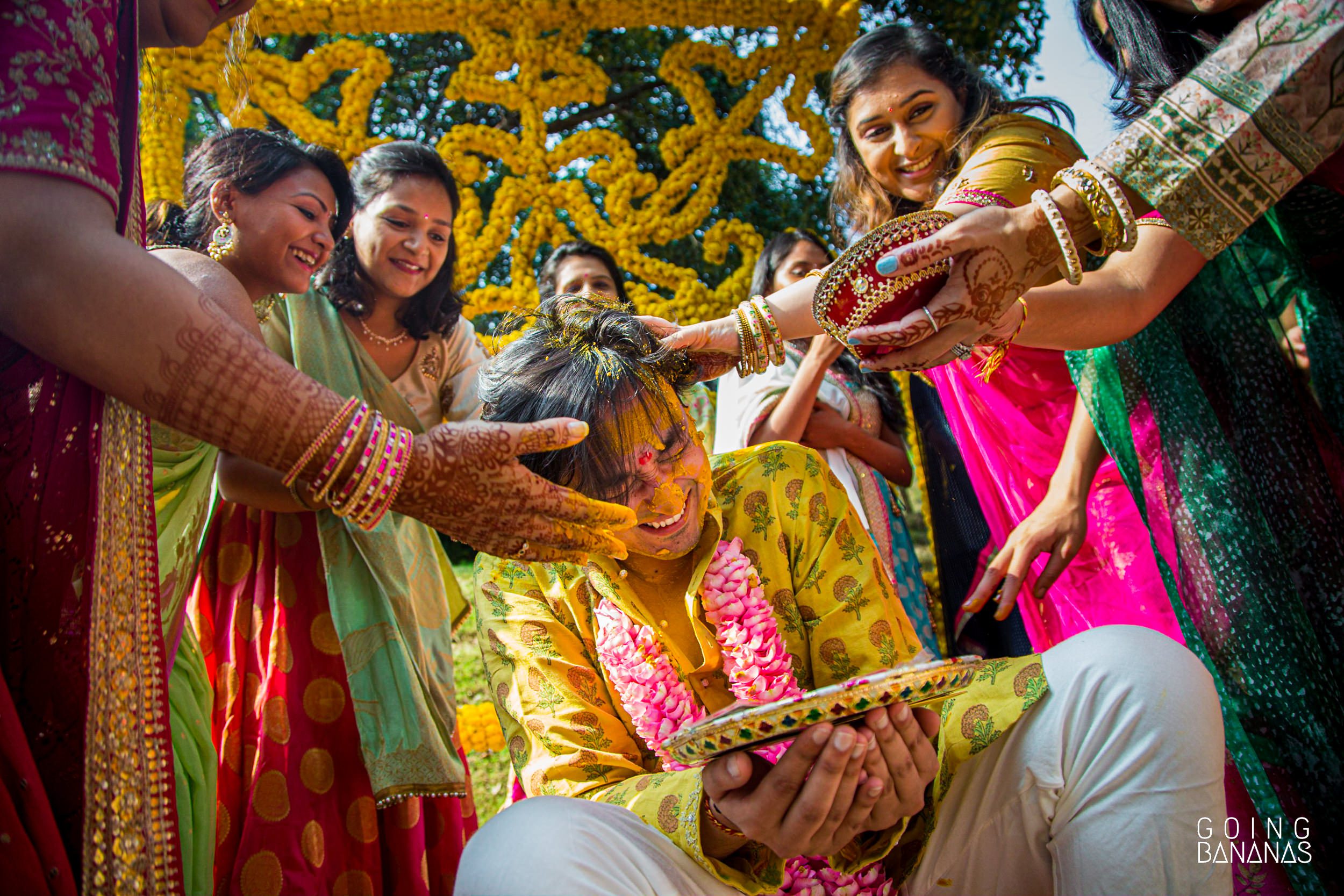 Relatives applying haldi to the groom at Taj Aravali Udaipur