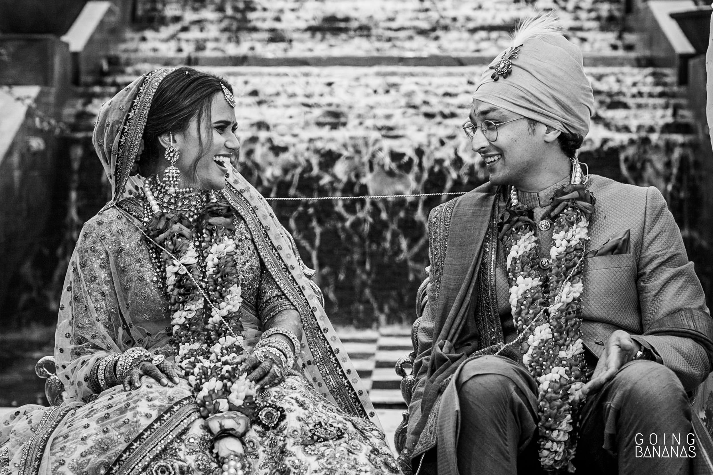 Bride and groom sharing a laugh in the middle of the wedding ceremony at Taj Aravali Udaipur