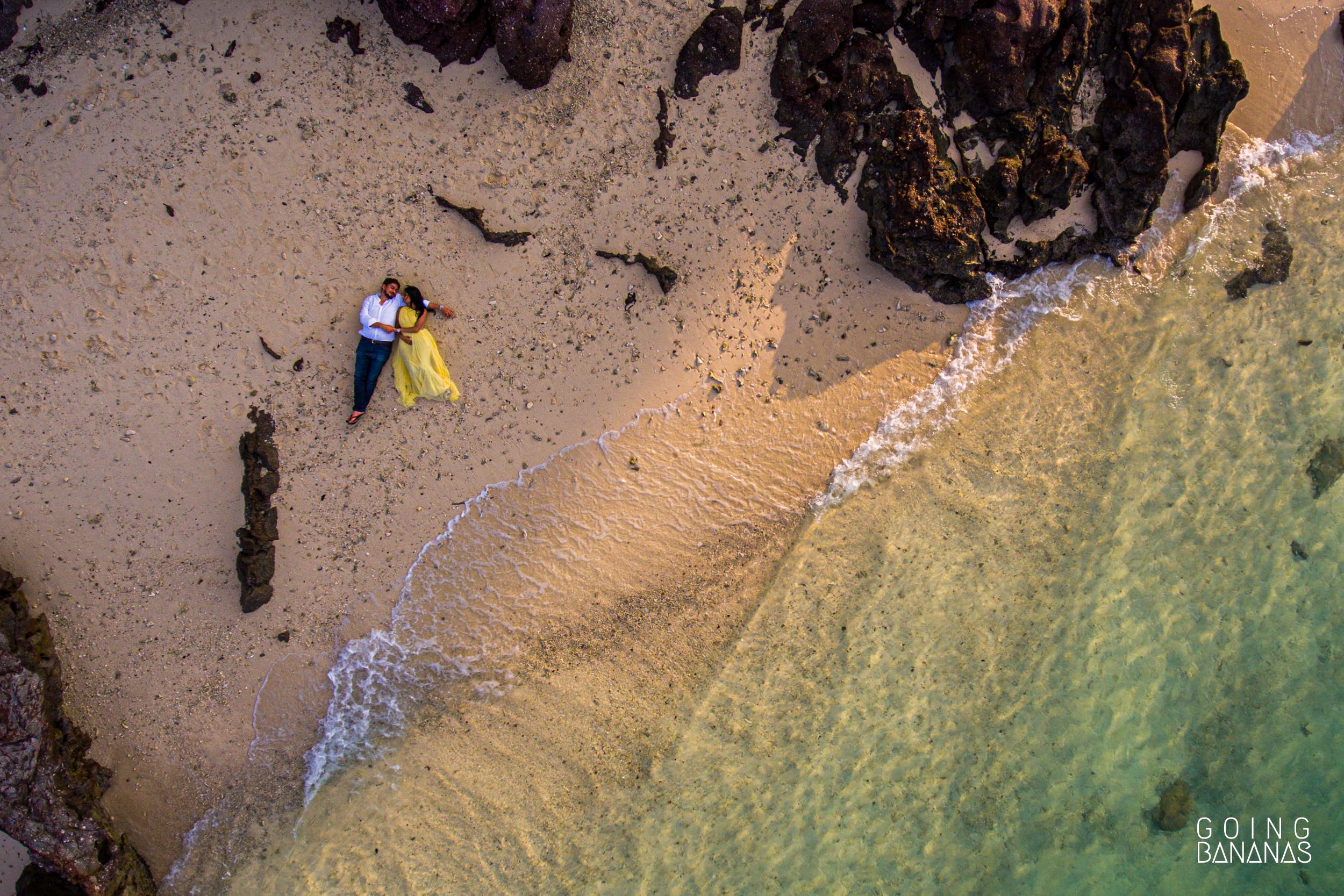 Aerial photo of bride and groom lying on the beach at Koh Talu in Rayong Thailand